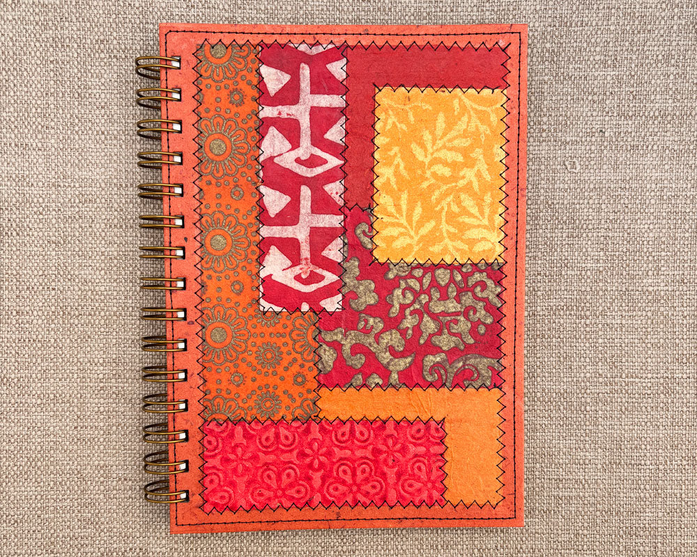 front of handmade spiral notebook with red and orange patchwork cover