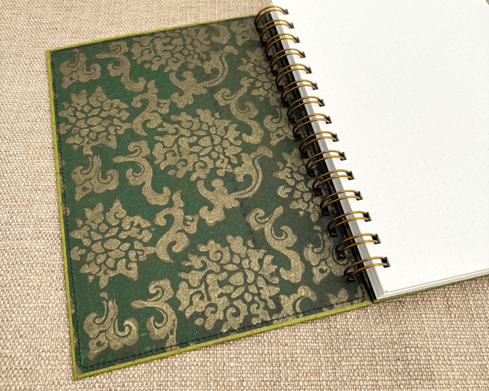 inside cover of green handmade spiral notebook with white lined pages