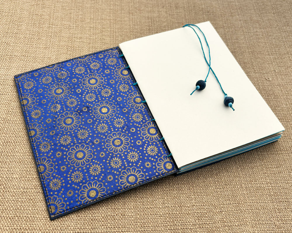 inside cover of hand bound journal featuring blue and gold handmade paper lining