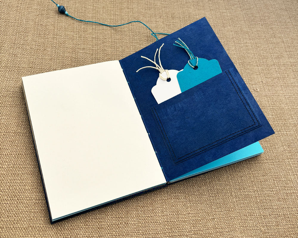 blue and white tags in pocket inside hand bound journal