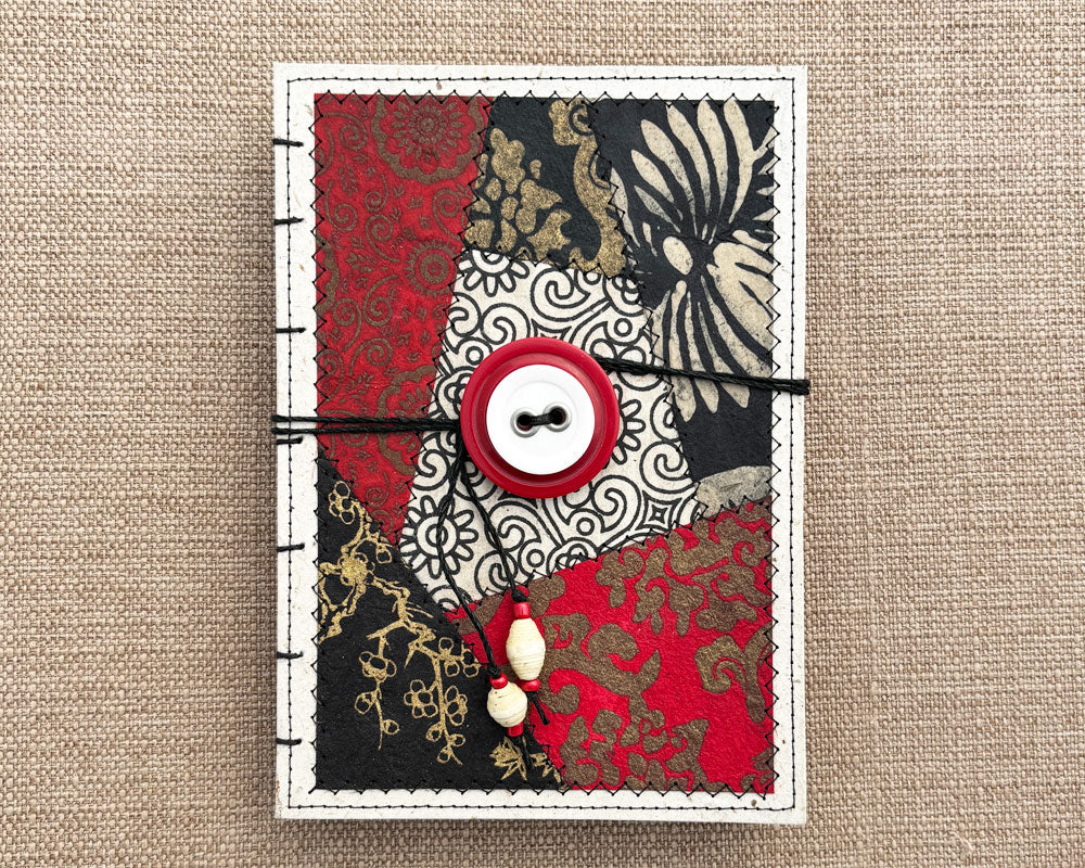front of hand bound journal with black white and red patchwork cover design