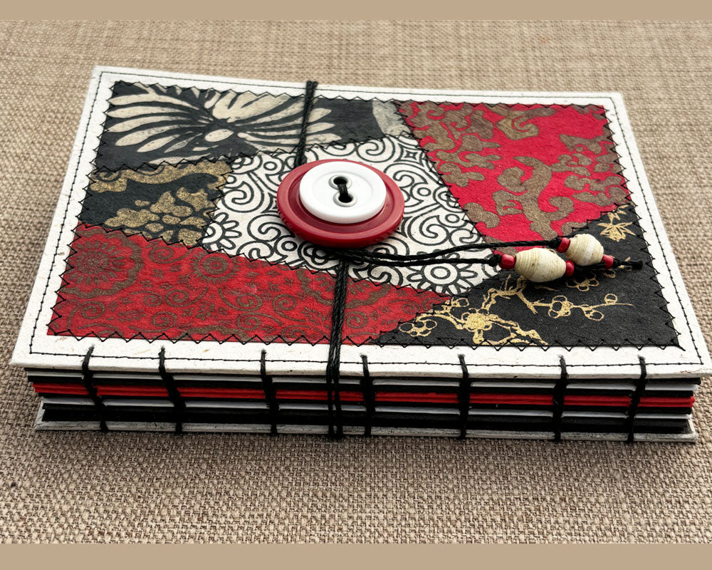 hand stitched spine of red black and white journal