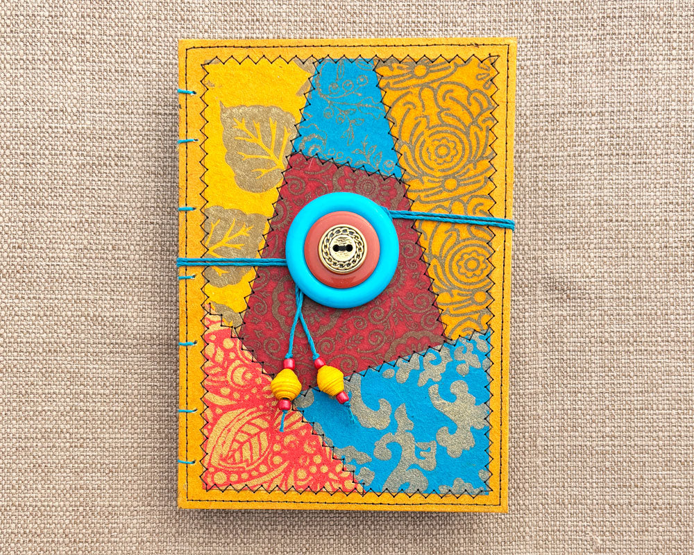 front cover of hand bound journal with red gold and turquoise patchwork design