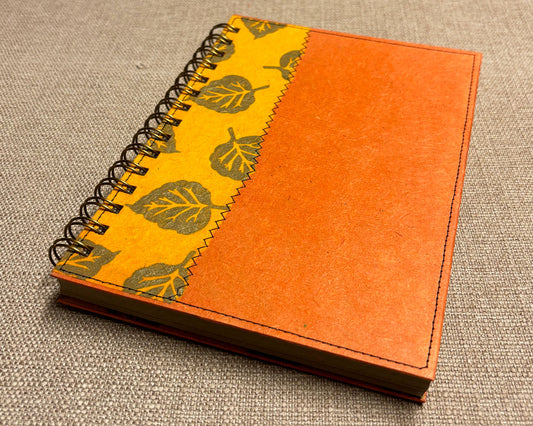 handmade spiral notebook with golden orange cover featuring autumn leaves