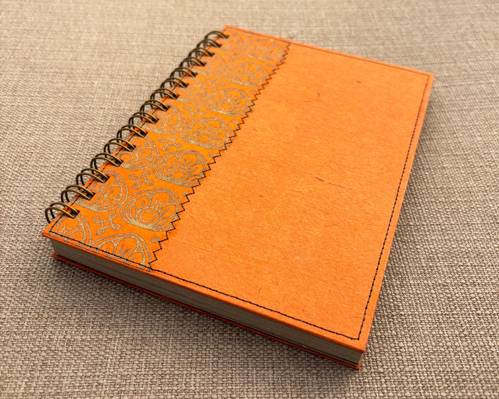 handmade spiral notebook featuring orange cover with gold lotus flower design