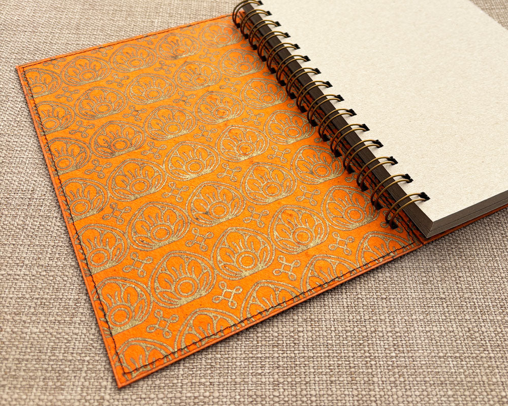 inside cover of spiral notebook with orange and gold lotus flower design