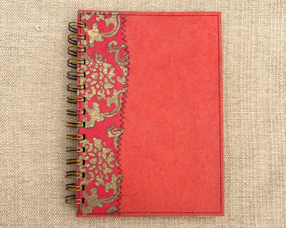 Red spiral notebook with gold floral patterns