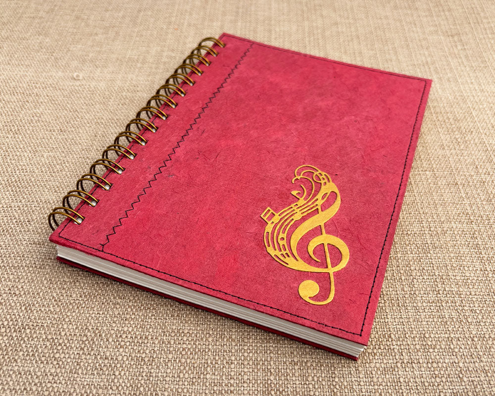 handmade spiral notebook feaaturing red cover with gold treble clef in corner